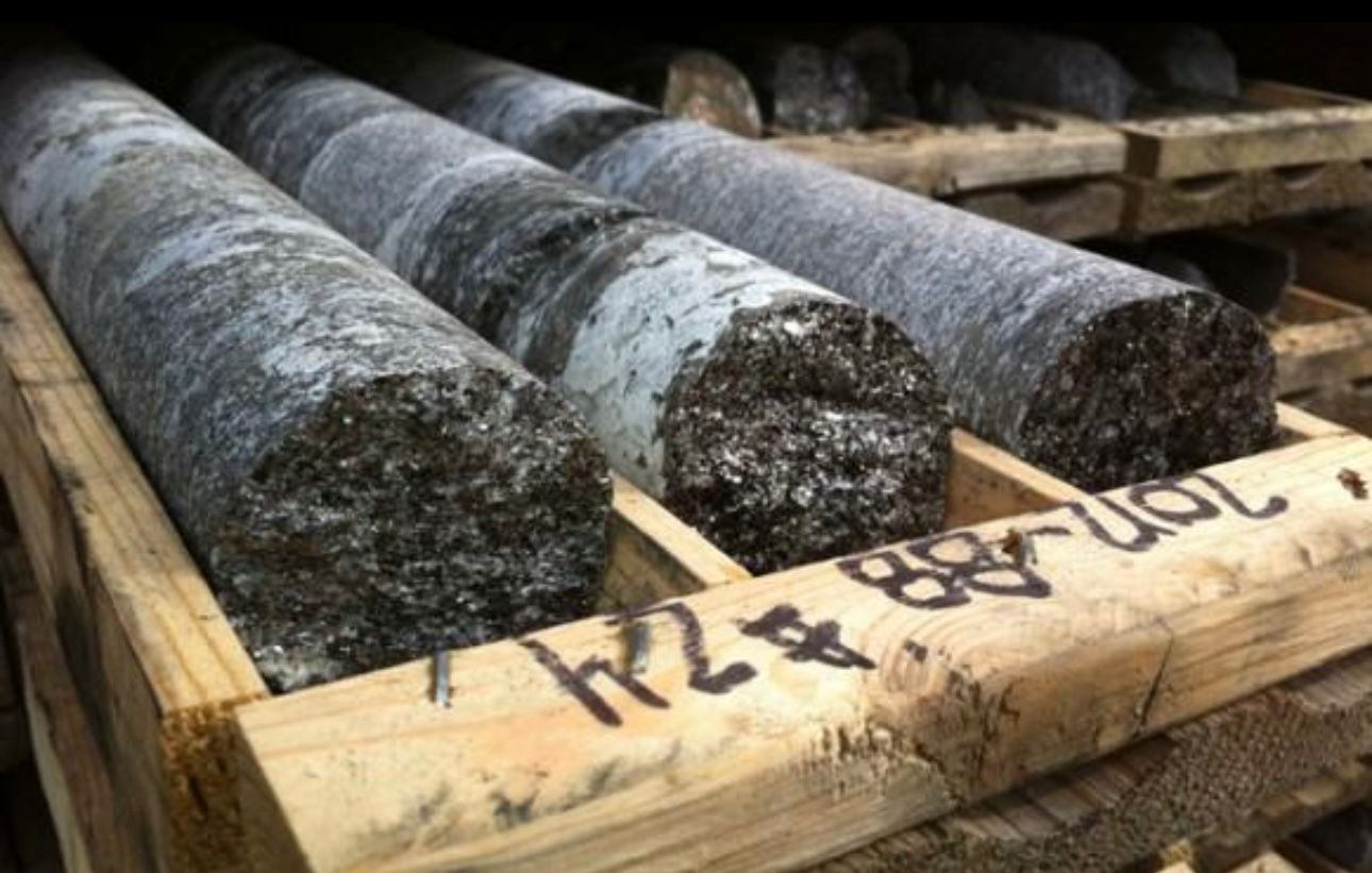 Graphite drill core samples arranged in a wooden crate for resource evaluation