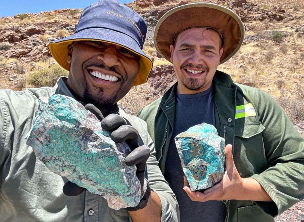 Field team holding copper-bearing rock samples at the Sinclair project site